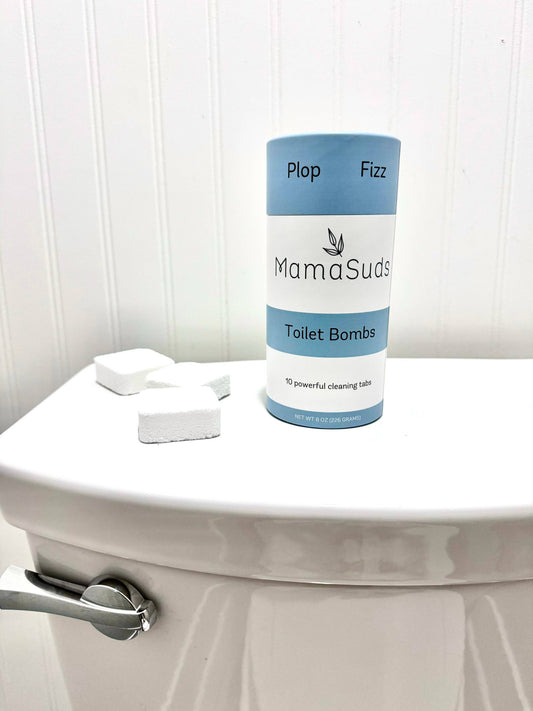 MamaSuds Toilet Bombs canister beside toilet with natural cleaning tablet ready for use.