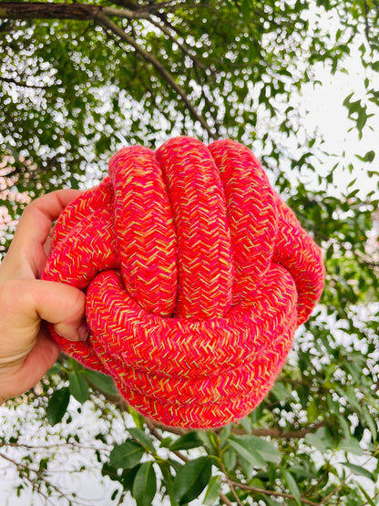Hand holding Handmade Jumbo Rope Ball Dog Toy for size reference