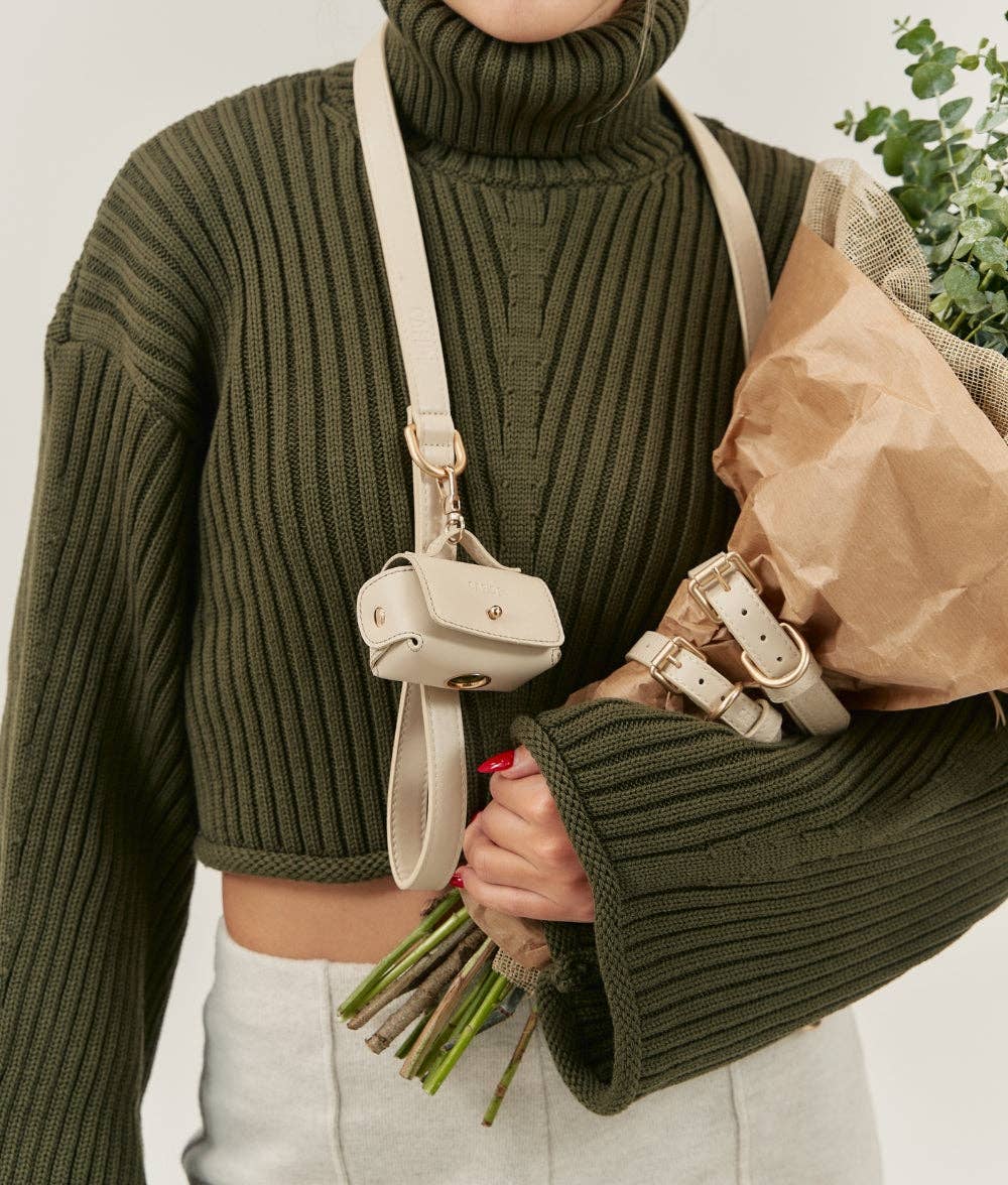 Close-up of the Beige Jala vegan leather leash worn crossbody