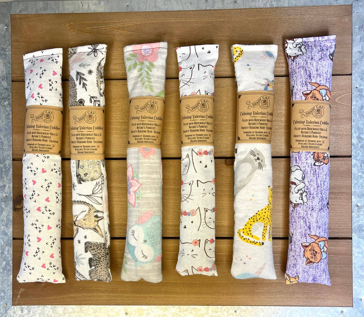 Handmade valerian cat cuddlers in assorted fabrics with branded paper wraps